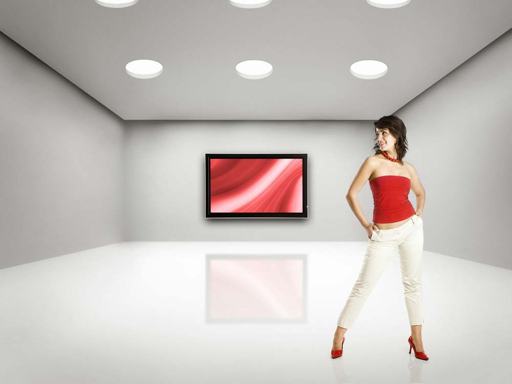 woman wearing a red shirt and white pants in a white room with a TV